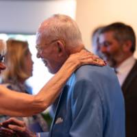 Two reception guests smiling at each other.